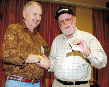 Festival co-sponsor Boyd Magers presents a $100 prize to TV Westerns Trivia Contest winner Jimmie Covington.