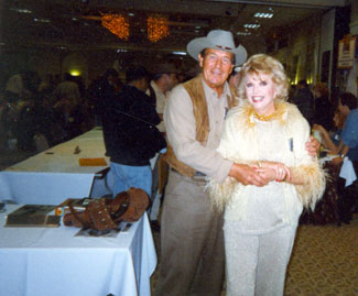Don Durant, TV’s “Johnny Ringo”, gives a hug to Ruta Lee at a Hollywood Collector’s Show in the ‘90s. Note Durant’s LeMat on his autograph table.