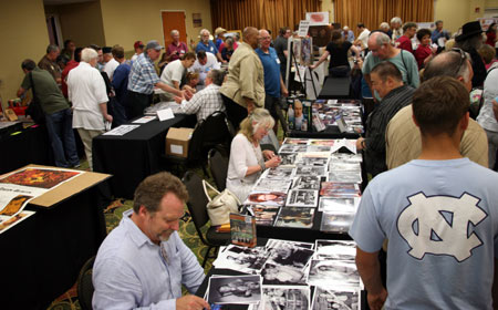 Darby Hinton and Veronica Cartwright, brother and sister on “Daniel Boone”, sign autographs for fans in the dealer’s room. Don Pedro Colley can be seen standing in the tan jacket.