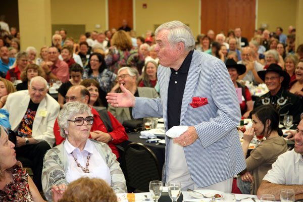 At the banquet, Ed Faulkner rises to accept his award. His wife Barbara is seated beside him. 