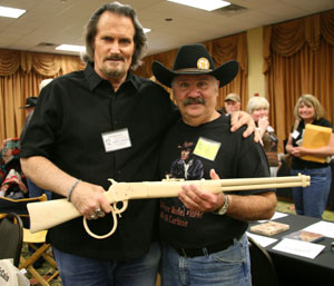 The Rifleman’s real son, Jeff Connors, holds an expertly crafted wooden replica by Stan Wilson (right) of Chuck Connors’ rifle from “The Rifleman”. 