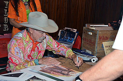 Buck Taylor signs one of his James Arness prints.
