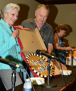 Lee Meriwether, assisted by Boyd Magers accepts a huge Happy Birthday cookie from Trivia Contest winner Don Ellis.