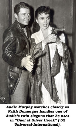 Audie Murphy watches closely as Faith Domergue handles one of Audie's twin sixguns that he uses in "Duel at Silver Creek" ('52 Universal-International).