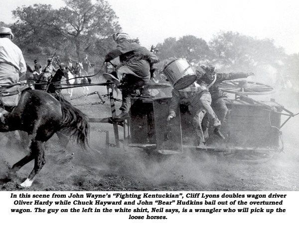 In this scene from John Wayne's "Fighting Kentuckian", Cliff Lyon doubles wagon driver Oliver Hardy while Chuck Hayward and John "Bear" Hudkins bail out of the overturned wagon. The guy on the left in the white shirt, Neil Summers says, is a wrangler who will pick up the loose horses.
