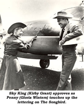 Sky King (Kirby Grant) approves as Penny (Gloria Winters) touches up the lettering on The Songbird.