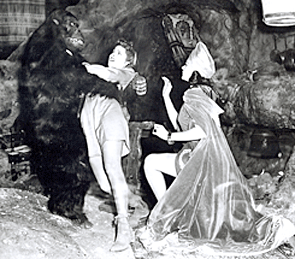Scene from "Perils of Nyoka" serial showing gorilla holding Nyoka with Vultura close at hand.