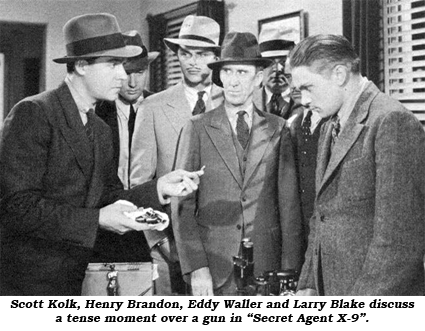 Scott Kolk, Henry Brandon, Eddy Waller and Larry Blake discuss a tense moment over a gun in "Secret Agent X-9".