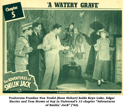 Traitorous Frauline Von Teufel (Rose Hobart) hold Keye Luke, Edgar Barrier and Tom Brown at bay in Universal's 13 chapter "Adventures of Smilin' Jack" ('42).