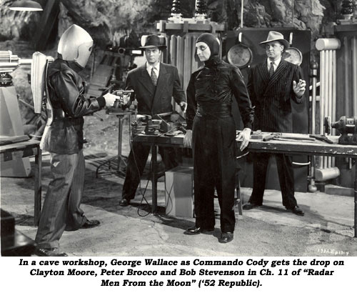 in a cave workshop, George Wallace as Commando Cody gets the drop on Clayton Moore, Peter Brocco and Bob Stevenson in Ch. 11 of "Radar Men From the Moon" ('52 Republic).