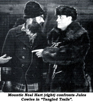 Mountie Neal Hart (right)A confronts Jules Cowles in "Tangled Trails".