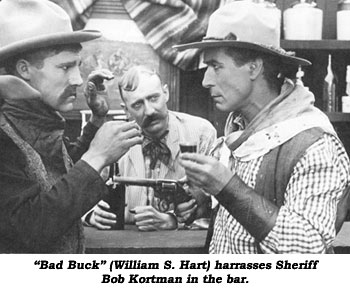 "Bad Buck" (William S. Hart) harrasses Sheriff Bob Kortman in the bar.