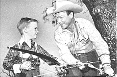 Roy Rogers teaches his son, eight year old Roy Rogers Jr. ("Dusty"), how to use a bow and arrow for an episode of Roy's TV series, "Three Masked Men" which aired on NBC 12/18/55.