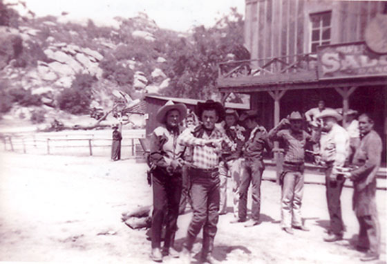 Ray "Crash" Corrigan gets the drop on an outlaw during a live show at Corriganville, circa 1955. Max Terhune (right in white shirt) and Chief Thunder Cloud (far right) hold other outlaws at bay.