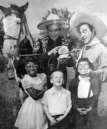 The Cisco Kid (Duncan Renaldo) and Pancho (Leo Carrillo) clown around with a 
group of young fans. 