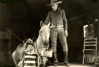 Ken Maynard and Tarzan surprise a young fan during a stage presentation 
in the early ‘30s. 