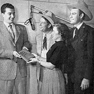 COUNTRY SONG ROUNDUP magazine columnist and KFVD Los Angeles radio DJ George Sanders accepts a gold plaque in 1950 from KFI-TV reporter Gloria Grant. The award, known as ‘The Western Life’, was presented every year by Tex Williams (right) and Smokey Rodgers to the person who has done the most to encourage western music in America. 