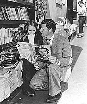Audie Murphy shows a young fan an article about himself in a movie magazine.