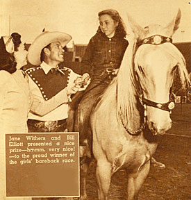 Bill Elliott presents a prize to the proud winner of the girls bareback race.