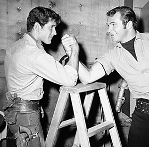 Robert Fuller and Burt Reynolds go at it for a publicity arm wrestling match on July 28, 1959 to see whose new series will come out a winner. Both Bob’s “Laramie” and Burt’s “Riverboat” began on NBC on September ‘59.