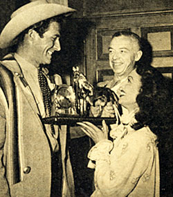 Following a guest star appearance on NBC TV’s “Letter to Loretta” in 1954, Loretta Young presents Jock Mahoney with an appropriate present.