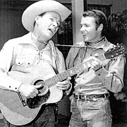 Roy Rogers and Audie Murphy promoting NBC’s “Chevy Show” (9/27/59), one of 14 color one hour Sunday programs broadcast between ‘58-‘60 that Roy and Dale hosted. During the program, Roy, Audie and Eddy Arnold sang together. 