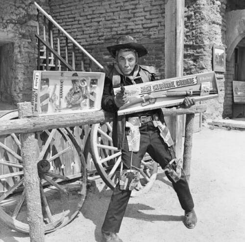 Cameron Mitchell as Buck Cannon has a little fun with the “High Chaparral” toy gun and holster set and Daisy Carbine. (Thanx to Terry Cutts.) 