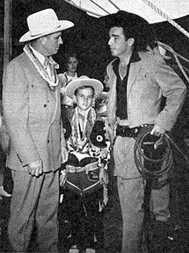 Gene Autry stopped off to meet Lash LaRue while both were appearing at an Illinois State Fair. Young fan in the middle is Roger Ladage of Vernon, IL. 