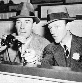 Randolph Scott and Fred Astaire share a box and a pair of field glasses at Santa Anita Turf Club in 1938. 