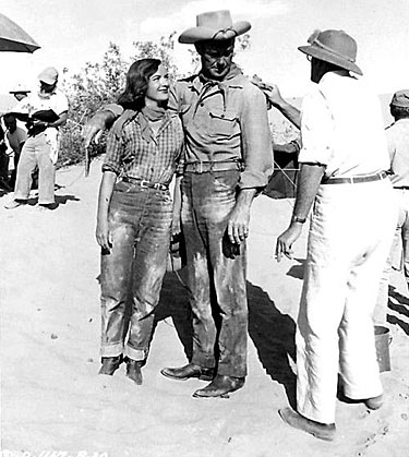 Director John Sturges applies just a bit more dirt to Randolph Scott and Ella Raines before the next scene of “The Walking Hills” (‘49). 