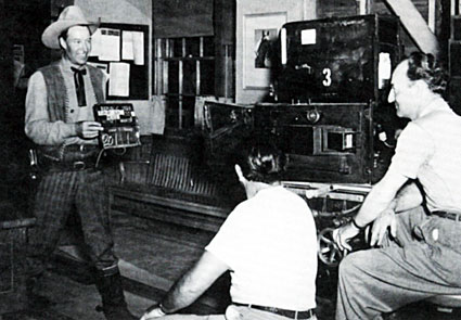 Bill Elliott holds a slate for the next scene for Republic cinematographer Jack Marta. 