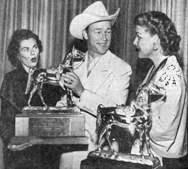 Roy Rogers holds a gold statuette of Trigger while actresses Barbara Hale (left) and Ann Sheridan look on with approval. The statuettes were presented to Britton Elementary School in Oklahoma City whose students won the Roy Rogers Safety Award for their posters. 