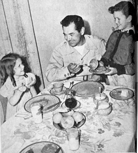 Johnny Mack Brown, stowing away a batch of flapjacks with daughter Cynthia and son Lachlan in November 1944.