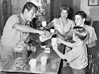 Gene (“Bat Msterson”) Barry pours a glass of milk for his wife Betty and sons Michael, 14, and Frederick, 8, in 1960. 