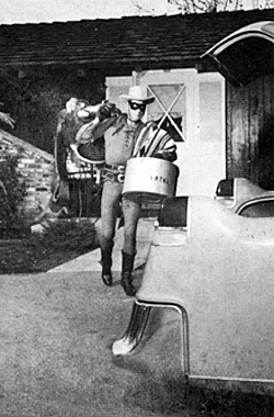 Sorry Silver, the Lone Ranger (Clayton Moore) prepares to load his saddle and tack in his Cadillac. 