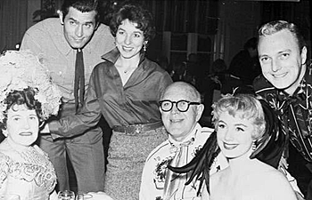 Clint Walker on an unknown game show with three participants and actors Jack Cassidy and Shirley Jones on the right. 