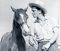 John Carroll, star of Republic serial “Zorro Rides Again” and other Westerns, on his 800 acre Granada Hills, CA, horse ranch beside his favorite mount, Pal. 