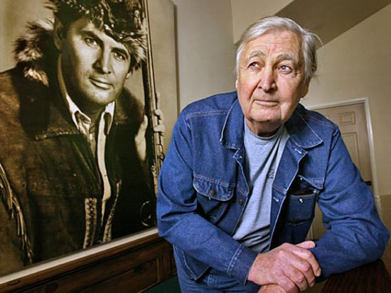 Fess Parker at his winery and vineyards in Los Olivos, CA, beside a large photo of him as Davy Crockett.
