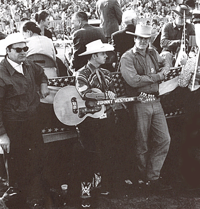 Johnny Western (center), James Arness and Steve McQueen at the September 1958 dedication of Gunsmoke Street in Dodge City, Kansas. Note Milburn Stone and Amanda Blake above Johnny on the dais. Also in attendance, not pictured, were Chill Wills, David Janssen, Robert Culp. (Thanx to Johnny Western.) 