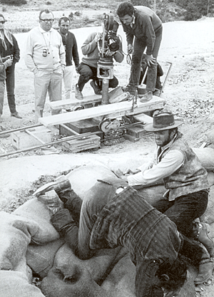 Director Sergio Leone (in white shirt) films a scene with Clint Eastwood and Eli Wallach just after the explosion of Branson Bridge in "The Good, the Bad and the Ugly". 