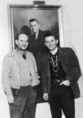 Lee "Lasses" White and Jimmy Wakely at the Variety Club in Oklahoma City in front of a painting of humorist Will Rogers. 