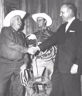 Ken Maynard at Movieland Wax Museum in Buena Park, CA, standing next to his replica and shaking hands with Movieland founder Allen Parkinson. 