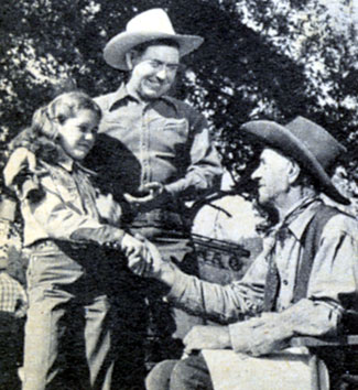 Johnny Mack Brown introduces his daughter, 12 year old Cynthia, to Milburn Morante, Johnny’s co-star in “Outlaw Gold” (‘50 Monogram).