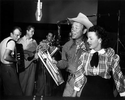 Roy Rogers and Dale Evans recording a song together in 1955.
