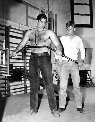 Will (“Sugarfoot”) Hutchins watches as Clint (“Cheyenne”) Walker works out in the Warner Bros. gym.