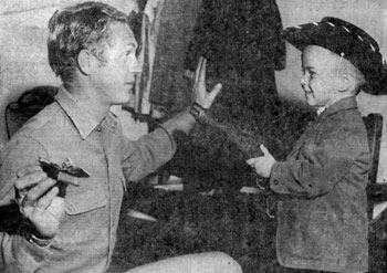 Five year old Randy Cooper of Albuquerque covers Steve McQueen of “Wanted Dead or Alive” with McQueen’s own “mare’s laig” (a cut down version of a Model 92 Winchester 44-40 rifle). McQueen was appearing at the New Mexico State Fair in October 1959.