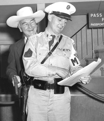 William Boyd (Hopalong Cassidy) arrives at the Rhein-Main Airport in Frankfort, Germany, August 27, 1954, to begin a European vacation with his wife Grace. For a publicity photo, Hoppy appears to be playfully swiping the M.P.'s weapon. (Thanx to Joel O'Brien.)