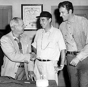 Meeting for the first episode of “Gunsmoke: Matt Gets It” in 1955 are (L-R) 1st assistant director Glenn Cooke, writer/producer/director Charles Marquis Warren and James Arness.