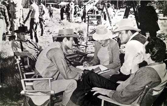 Dan Blocker, Gilbert Roland and the script supervisor discuss a scene for "Bonanza: The Lonely Runner" (10/10/65) as Kelly Thorsden (L) and Pat Conway (R-back to camera) listen intently.