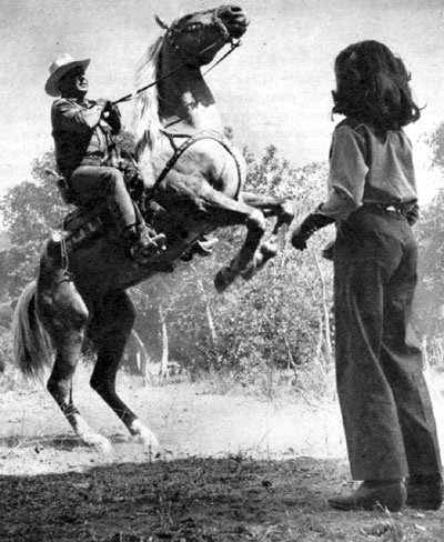 Johnny Mack Brown's daughter Cynthia watches her dad rear his palomino Rebel in November 1949. Cynthia was 12.